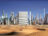 a digital collage of a radically built up city skyline overlooking a desert