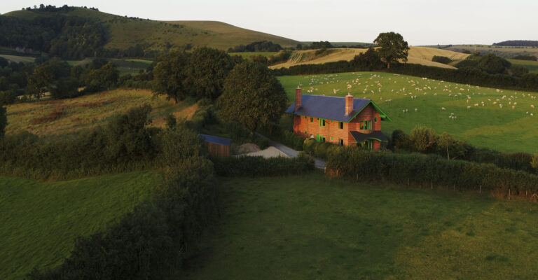 Red House surrounded by green fields.